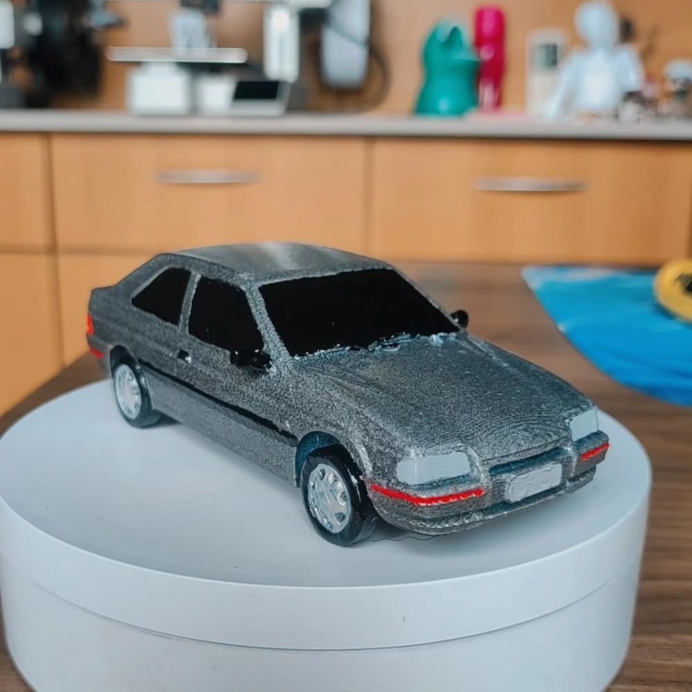 Miniatura de um Ford Escort cinza sobre base giratória